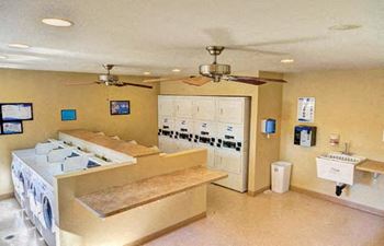 A laundry room with a washer and dryer stacked on top of each other at The Casas Apartments, San Diego, California